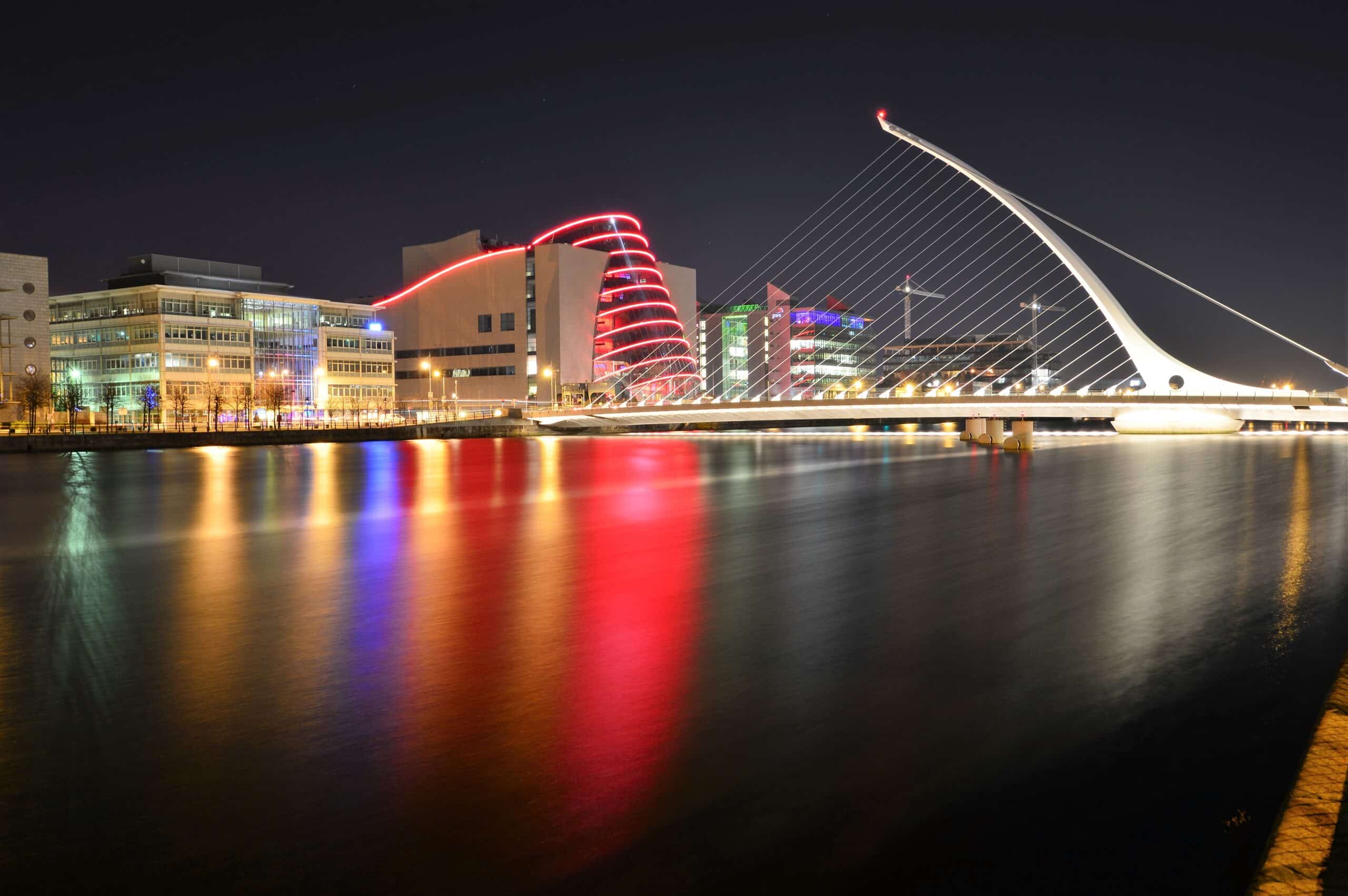 Long exposure photo showing the silhouette of the Convetion Centre, Dublin over the River Liffey at night. Also features The Samuel Beckett bridge.